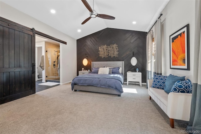 carpeted bedroom featuring ensuite bath, vaulted ceiling, a barn door, ceiling fan, and wood walls