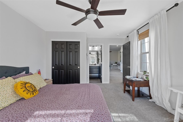 carpeted bedroom with a closet, ensuite bathroom, and ceiling fan