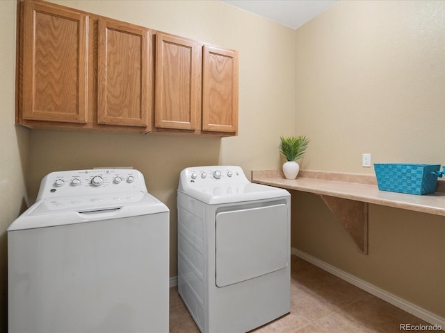 washroom with cabinet space, separate washer and dryer, and baseboards