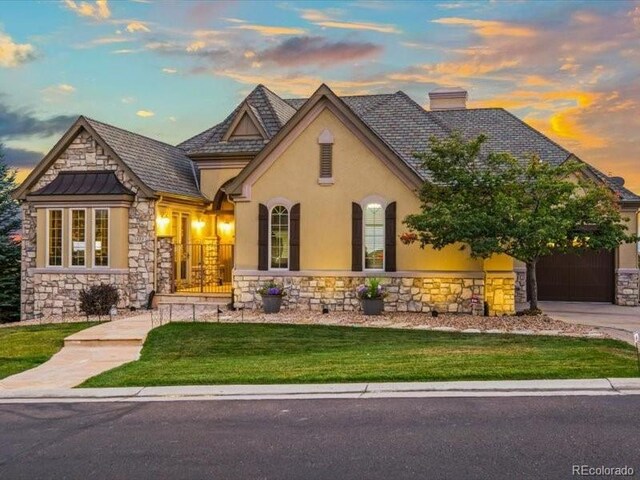 view of front of home featuring stucco siding, stone siding, and a chimney