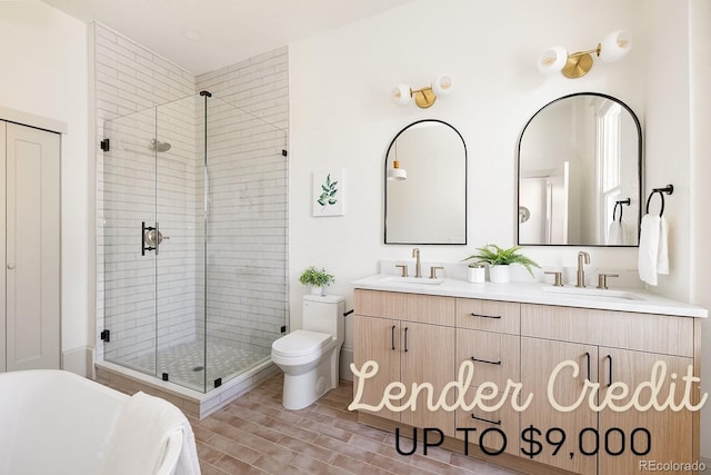 full bath featuring double vanity, a sink, toilet, and a shower stall