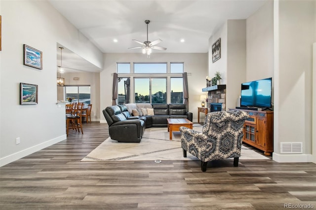 living room featuring a ceiling fan, wood finished floors, visible vents, baseboards, and recessed lighting