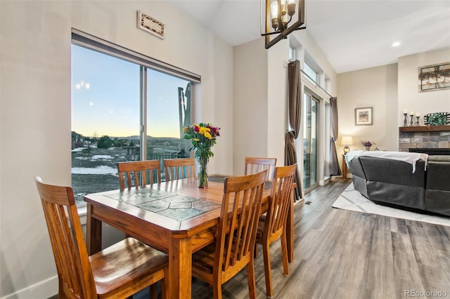 dining space with baseboards, an inviting chandelier, and wood finished floors