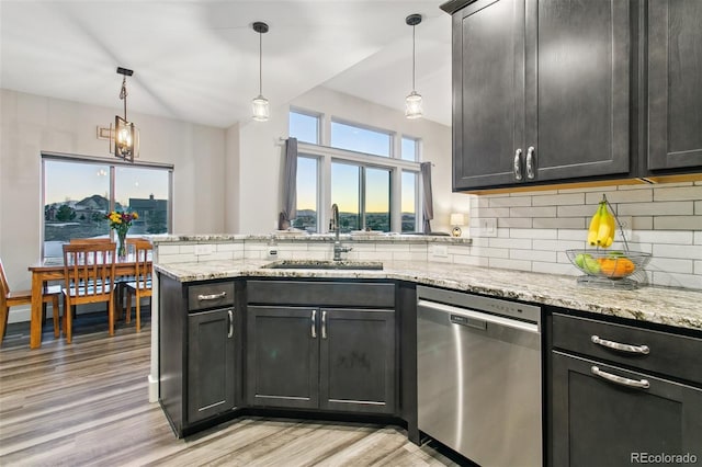 kitchen with light wood-style flooring, a sink, a peninsula, decorative backsplash, and dishwasher