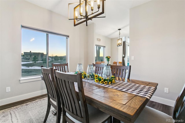 dining space featuring baseboards, wood finished floors, and a chandelier