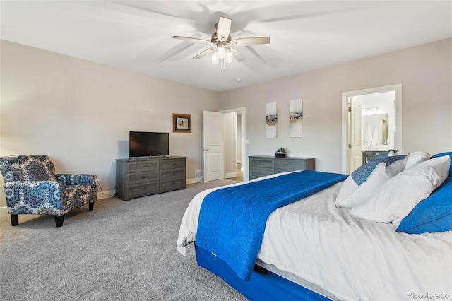 bedroom with baseboards, carpet floors, ensuite bath, and a ceiling fan