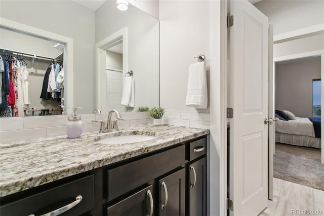 full bath featuring vanity, ensuite bath, a spacious closet, and marble finish floor