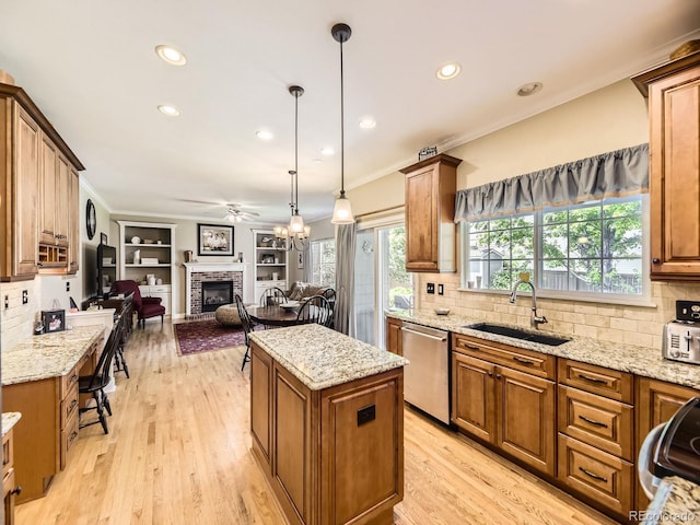 9625 S Hackberry St, Highlands Ranch, CO 80129 - kitchen with stainless steel dishwasher, a fireplace, a ceiling fan, open floor plan, and a center island