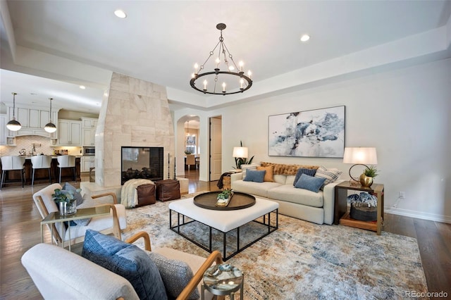 living room with arched walkways, a chandelier, wood finished floors, and recessed lighting