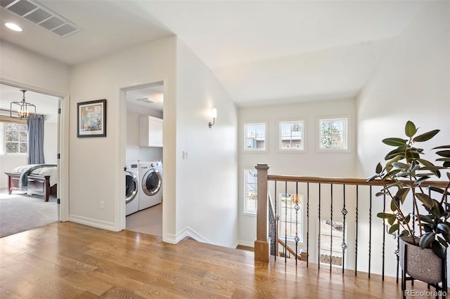 hallway with separate washer and dryer, recessed lighting, baseboards, wood finished floors, and visible vents
