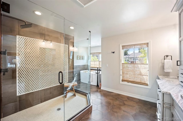 bathroom featuring a stall shower, vanity, baseboards, tile patterned floors, and recessed lighting