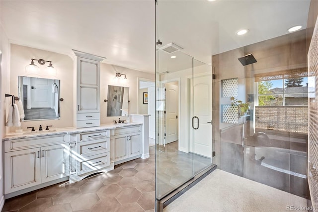bathroom featuring double vanity, visible vents, a tile shower, a sink, and tile patterned floors