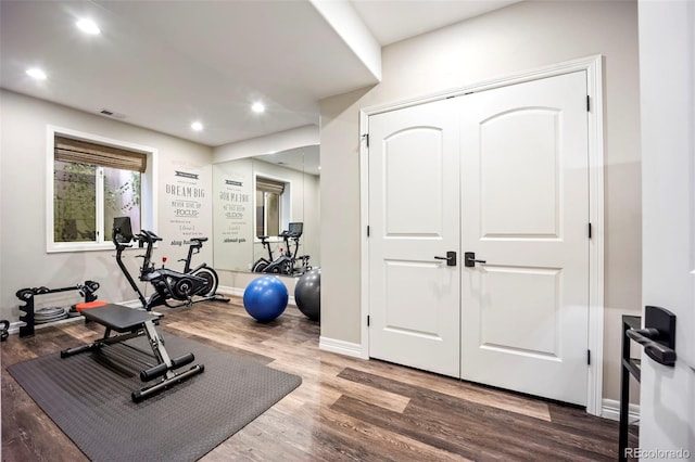 exercise area featuring visible vents, recessed lighting, baseboards, and wood finished floors