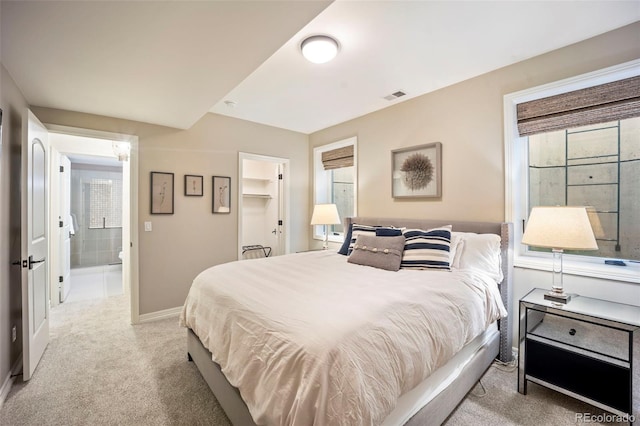 bedroom with carpet floors, baseboards, a walk in closet, and visible vents