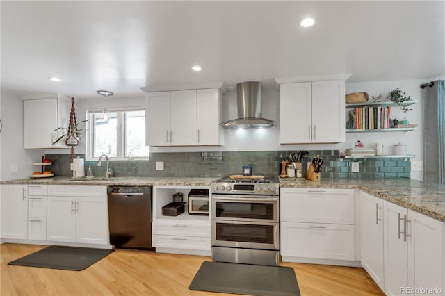 kitchen with open shelves, wall chimney exhaust hood, white cabinets, range with two ovens, and dishwasher