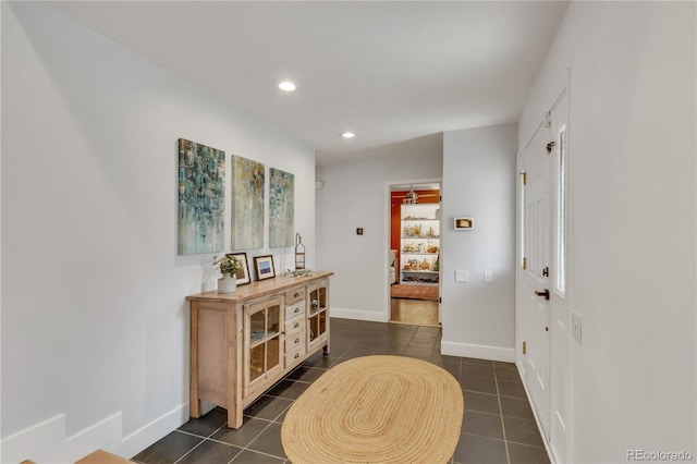 foyer with recessed lighting, baseboards, and dark tile patterned flooring