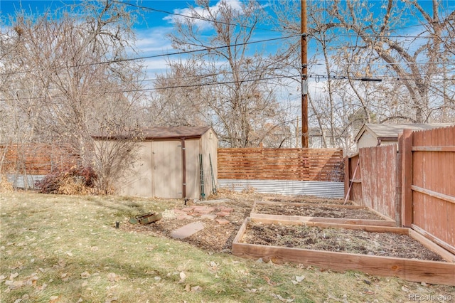 view of yard featuring an outbuilding, a storage shed, a vegetable garden, and fence