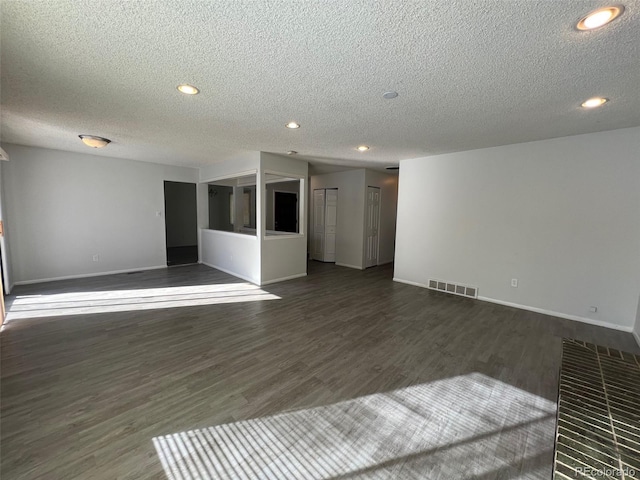 empty room with dark hardwood / wood-style flooring and a textured ceiling