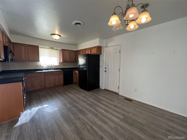 kitchen with dark hardwood / wood-style flooring, black appliances, pendant lighting, backsplash, and sink