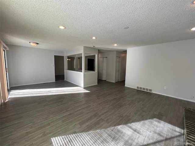 unfurnished room with a textured ceiling and dark hardwood / wood-style flooring