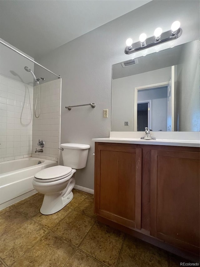 full bathroom with tile floors, toilet, vanity, and tiled shower / bath