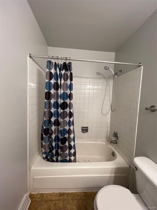 bathroom with shower / bath combo with shower curtain, toilet, and tile floors