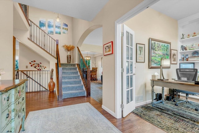 6266 Holman St, Arvada, CO 80004 - entryway with wood finished floors, arched walkways, stairway, and baseboards