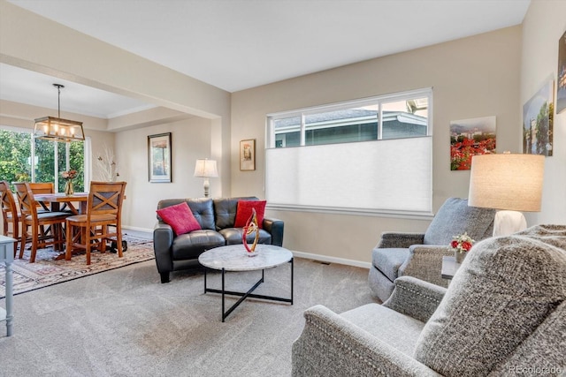 6266 Holman St, Arvada, CO 80004 - carpeted living room featuring baseboards, healthy amount of natural light, and a chandelier
