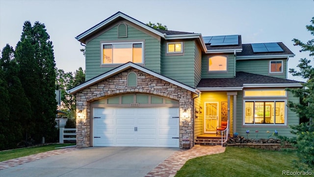 6266 Holman St, Arvada, CO 80004 - view of front of property featuring concrete driveway, stone siding, solar panels, a shingled roof, and a front lawn