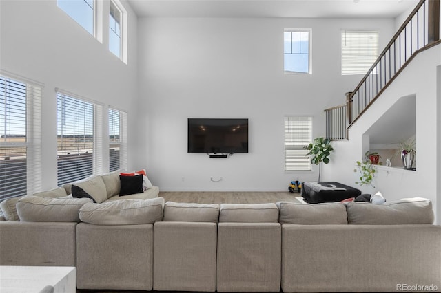 living room featuring a high ceiling and baseboards