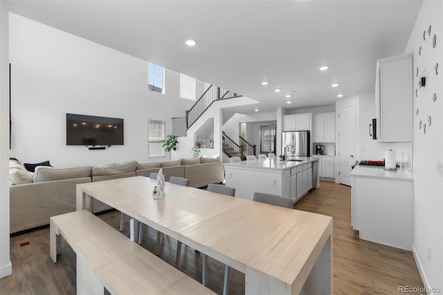 dining area featuring recessed lighting, stairway, and wood finished floors