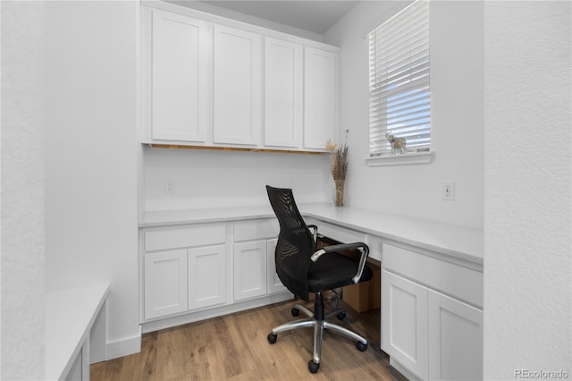 office area featuring built in desk and wood finished floors