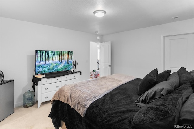 bedroom featuring visible vents and light colored carpet