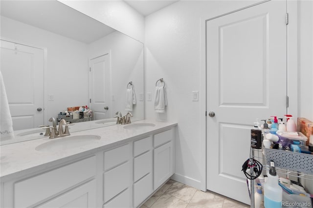 bathroom featuring double vanity, marble finish floor, and a sink