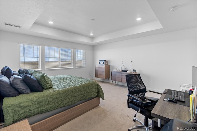 bedroom with recessed lighting, a tray ceiling, light colored carpet, and visible vents