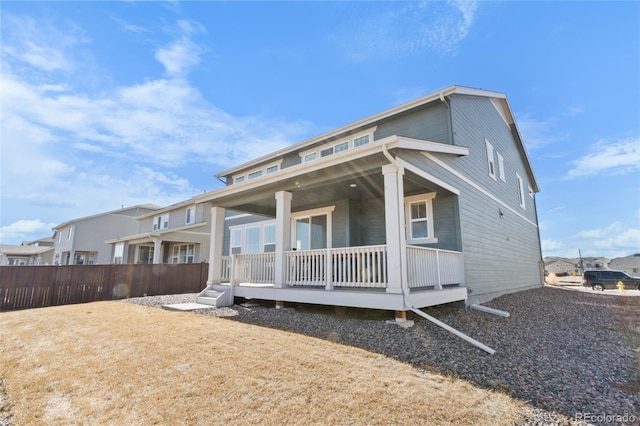 rear view of property with a porch and fence