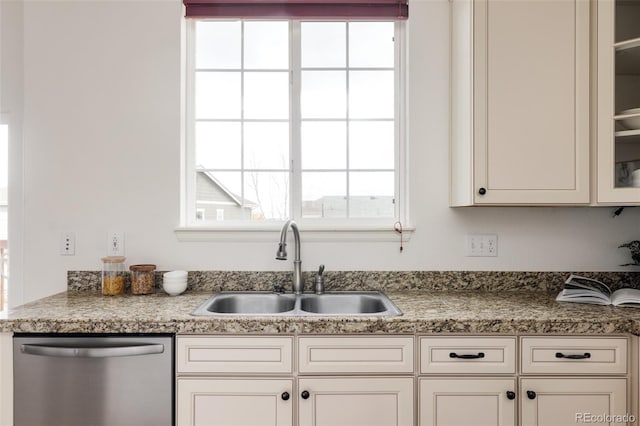 kitchen with dishwasher, white cabinetry, and sink