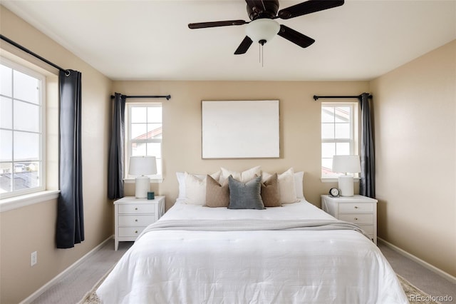 carpeted bedroom with ceiling fan and multiple windows