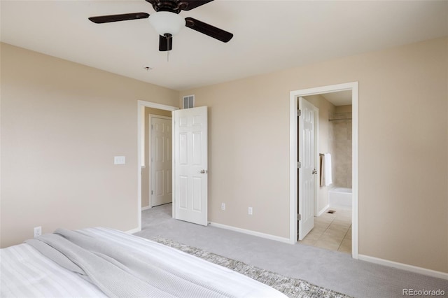 unfurnished bedroom with ensuite bathroom, light carpet, and ceiling fan