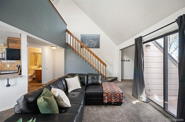 carpeted living room featuring a textured ceiling, stairway, and high vaulted ceiling