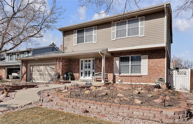 view of front of home with brick siding, fence, and an attached garage