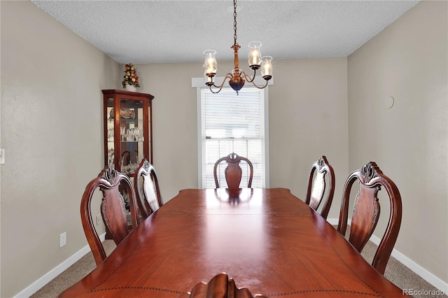 dining room with a textured ceiling, baseboards, and a notable chandelier