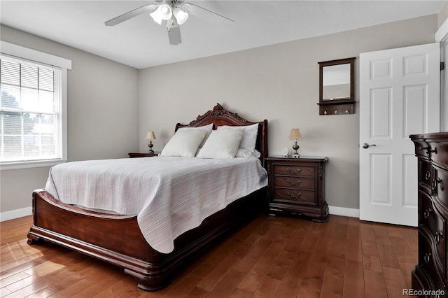 bedroom with dark wood finished floors, a ceiling fan, and baseboards