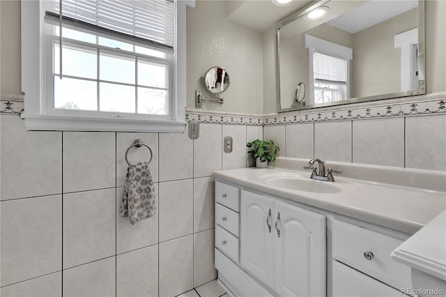 bathroom featuring a wainscoted wall, tile walls, and vanity