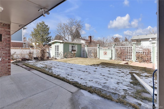 yard layered in snow with fence and an outdoor structure