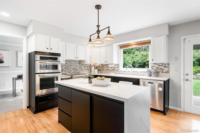 8288 W Chestnut Ave, Littleton, CO 80128 - kitchen with stainless steel appliances, white cabinets, backsplash, and pendant lighting