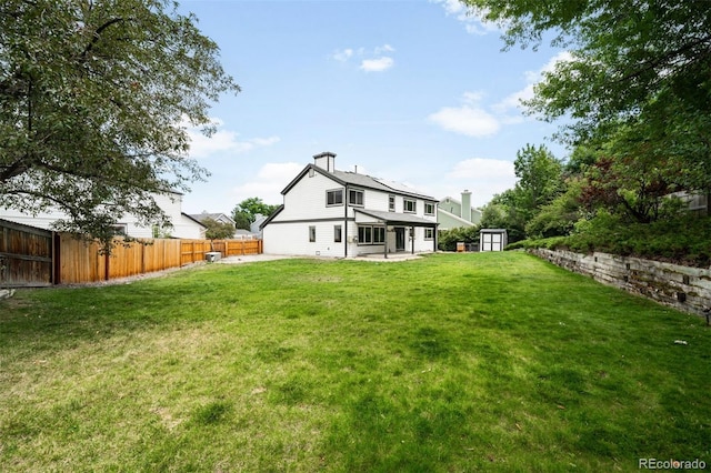 8288 W Chestnut Ave, Littleton, CO 80128 - back of property with a storage shed, a patio, a fenced backyard, and a chimney