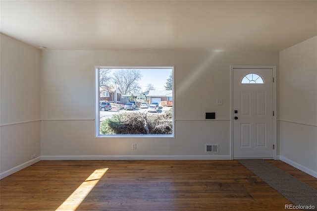 foyer entrance with visible vents, baseboards, and wood finished floors