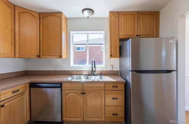 kitchen with dark countertops, appliances with stainless steel finishes, and a sink