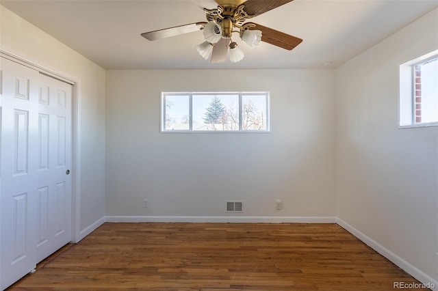 unfurnished bedroom featuring a closet, visible vents, baseboards, and wood finished floors